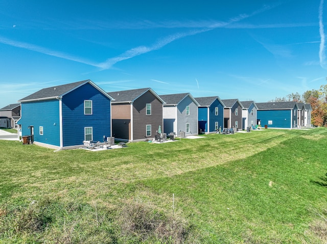 rear view of property with a patio, an outdoor fire pit, and a lawn