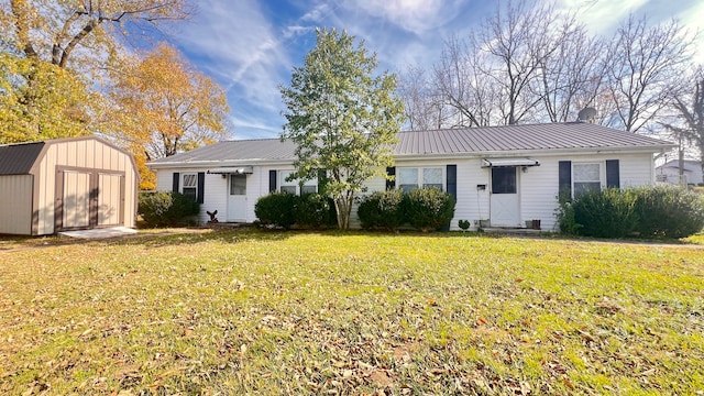 ranch-style home featuring a front lawn and a shed