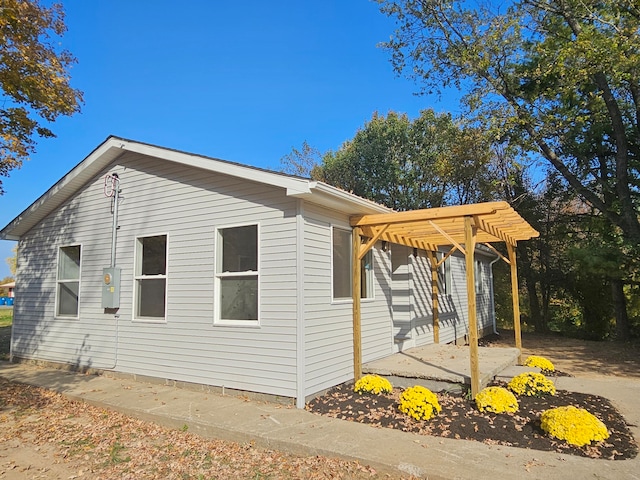 view of home's exterior with a patio area and a pergola