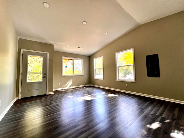 empty room with electric panel, vaulted ceiling, and dark hardwood / wood-style flooring