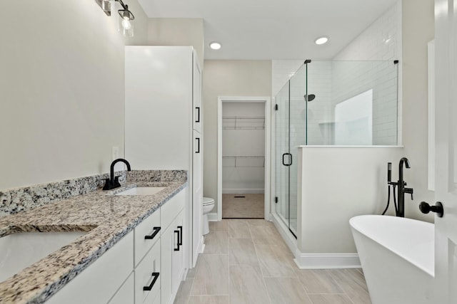 full bathroom featuring shower with separate bathtub, vanity, and toilet