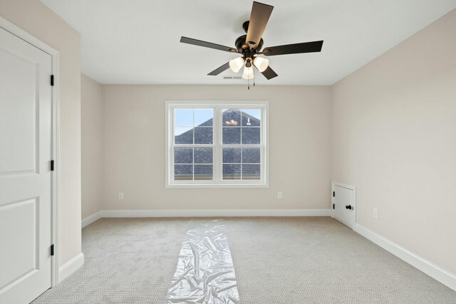 carpeted spare room featuring ceiling fan