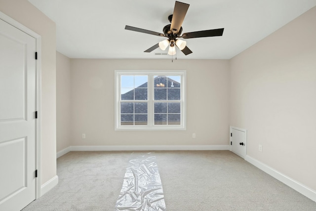 empty room featuring a ceiling fan, carpet flooring, visible vents, and baseboards