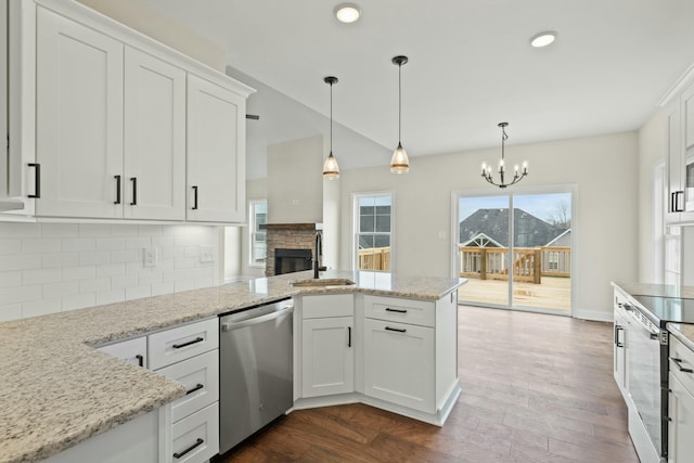 kitchen featuring appliances with stainless steel finishes, white cabinetry, dark wood-type flooring, and light stone counters