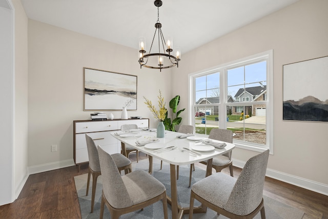 dining room featuring dark wood-style flooring, baseboards, and an inviting chandelier