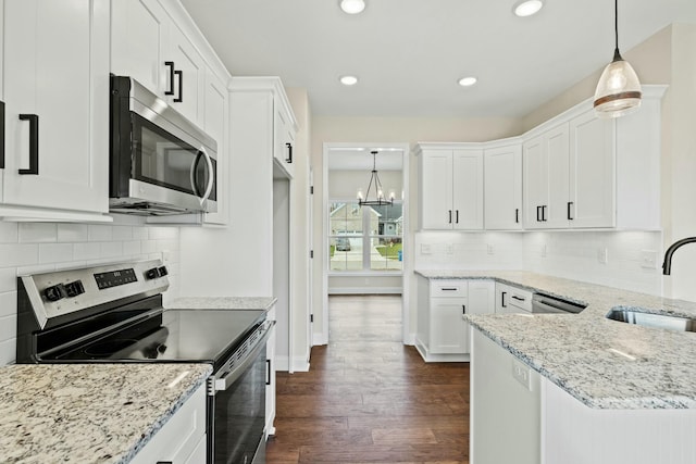 kitchen featuring appliances with stainless steel finishes, white cabinetry, and a sink