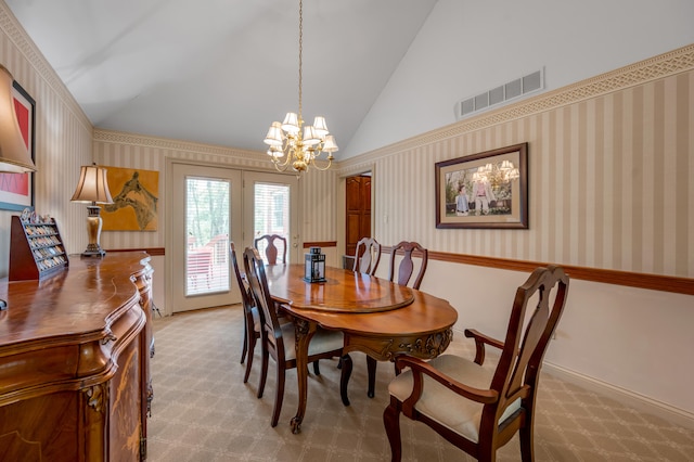 carpeted dining space featuring french doors, a chandelier, and high vaulted ceiling