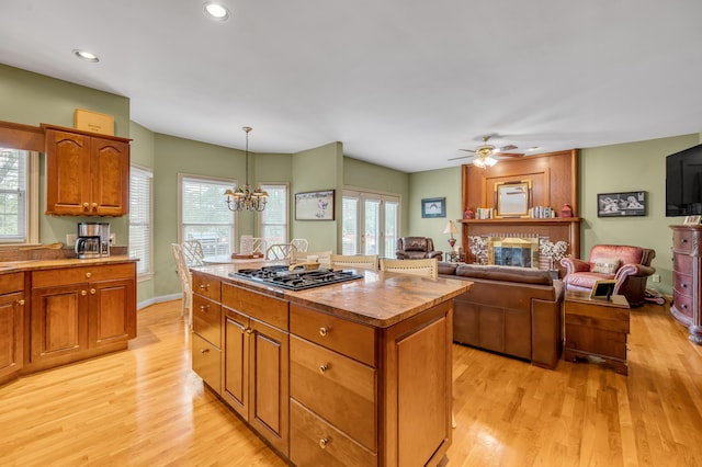 kitchen with a kitchen island, hanging light fixtures, light hardwood / wood-style floors, and plenty of natural light