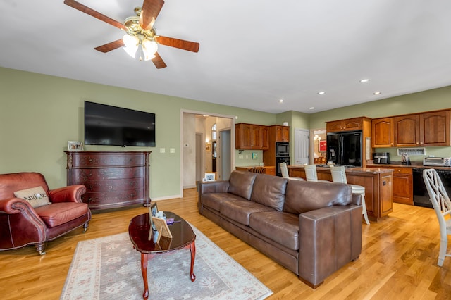 living room featuring light wood-type flooring and ceiling fan