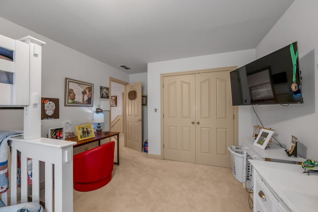 carpeted bedroom with a closet and a crib