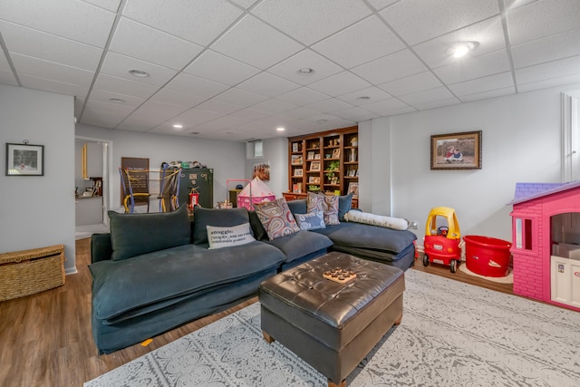 living room with a drop ceiling and light hardwood / wood-style flooring