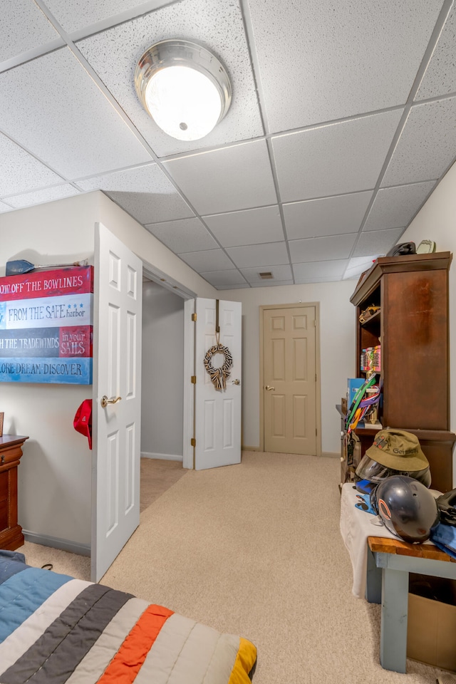 interior space with a drop ceiling and light colored carpet