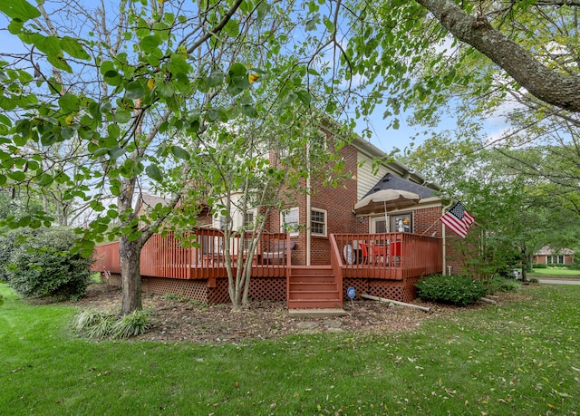 rear view of house featuring a yard and a wooden deck