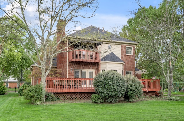 rear view of property featuring a wooden deck, a lawn, and a balcony