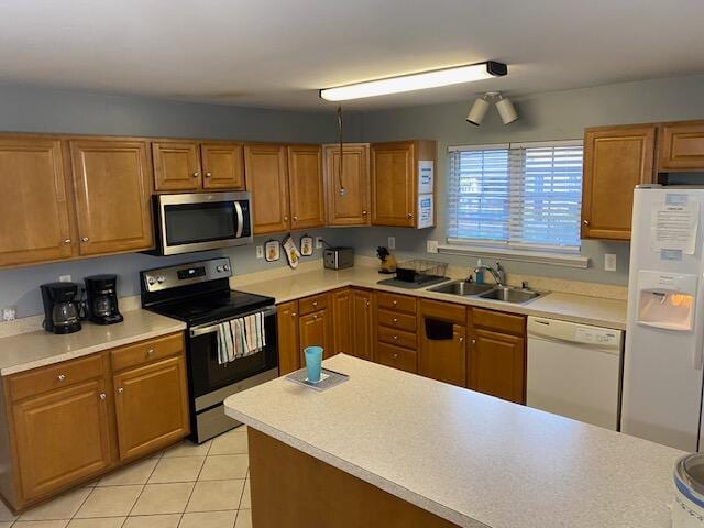 kitchen with stainless steel appliances, sink, and light tile patterned floors