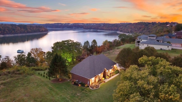 aerial view at dusk featuring a water view