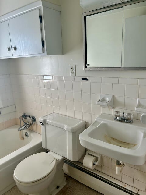 bathroom with tasteful backsplash, sink, toilet, tile walls, and a bathtub