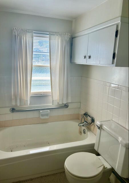 bathroom featuring a bathtub, toilet, and backsplash