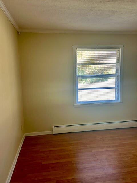 unfurnished room with a textured ceiling, wood-type flooring, a baseboard radiator, and ornamental molding