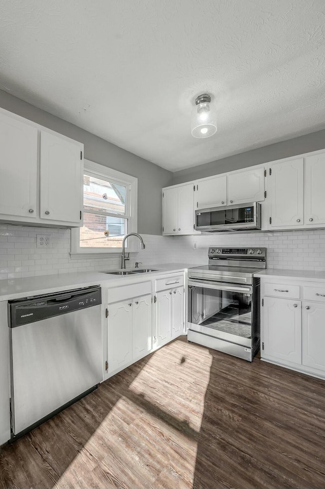 kitchen featuring a sink, stainless steel appliances, light countertops, and white cabinetry