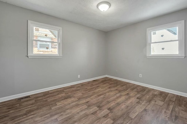 unfurnished room with dark wood-style floors and baseboards