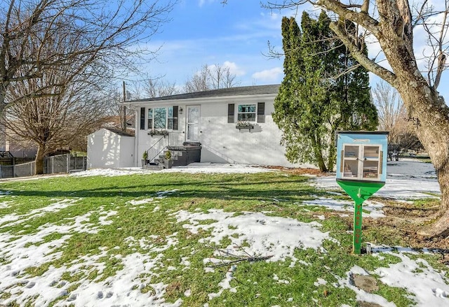 view of front of home featuring fence and a yard