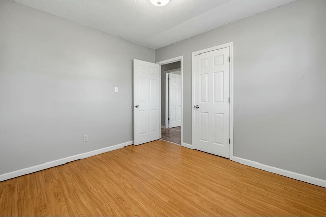 unfurnished bedroom featuring light wood finished floors and baseboards