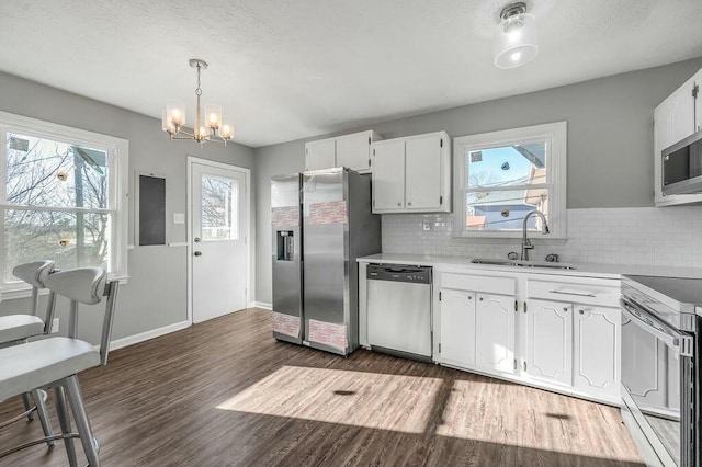 kitchen featuring a sink, stainless steel appliances, light countertops, and white cabinets