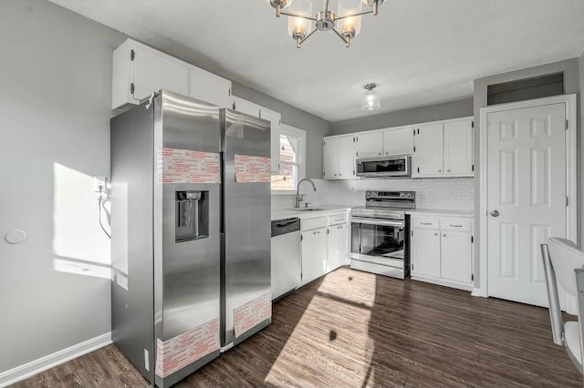 kitchen with dark wood-style floors, stainless steel appliances, tasteful backsplash, light countertops, and white cabinetry