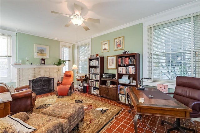 interior space with dark tile patterned floors, ornamental molding, a fireplace, and ceiling fan