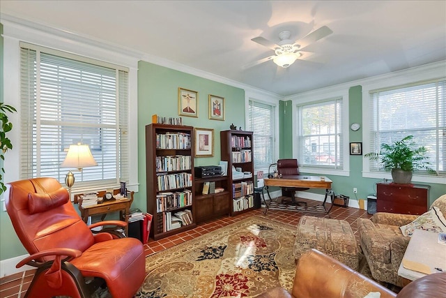 living area featuring crown molding, dark tile patterned floors, and ceiling fan