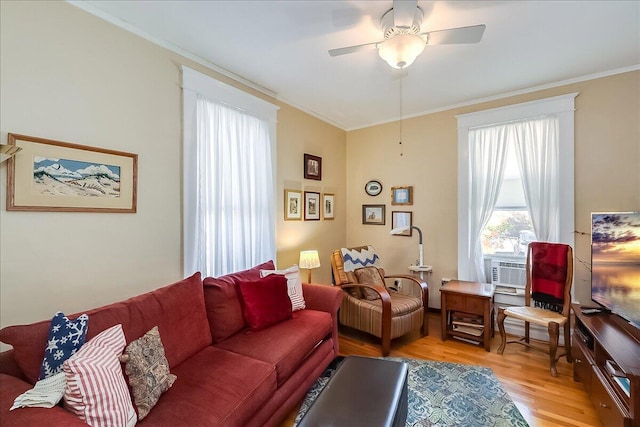 living room featuring crown molding, light wood-type flooring, and ceiling fan