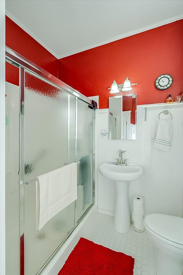 bathroom featuring a shower with door, toilet, and tile patterned floors