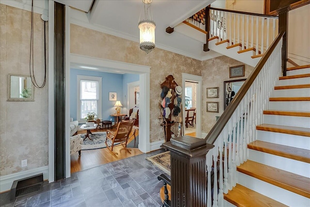 entrance foyer with crown molding, a chandelier, and dark wood-type flooring