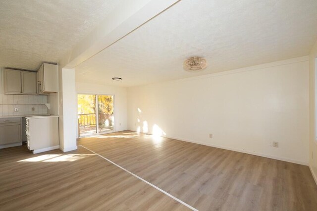 unfurnished living room featuring light hardwood / wood-style floors and a textured ceiling