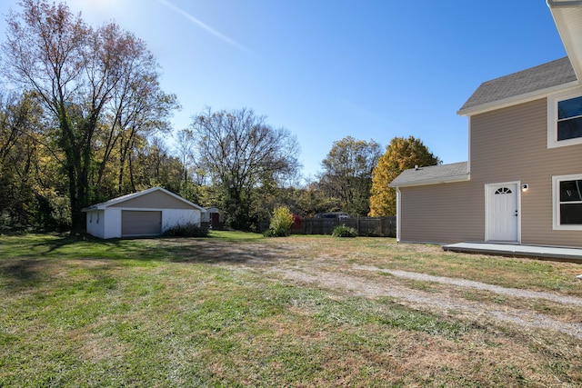 view of yard with a garage and an outbuilding