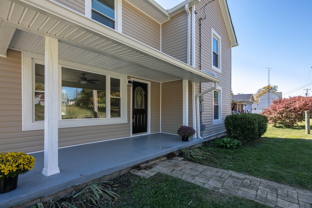 property entrance with a yard and ceiling fan