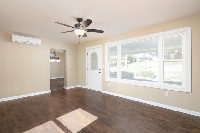 foyer entrance with an AC wall unit, dark wood-type flooring, and ceiling fan with notable chandelier