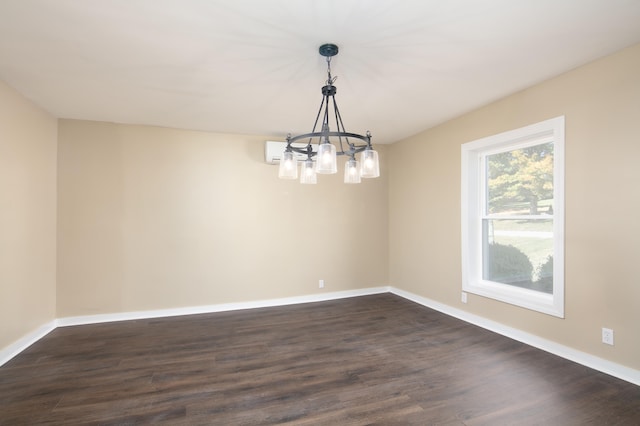 empty room with a chandelier and dark hardwood / wood-style floors