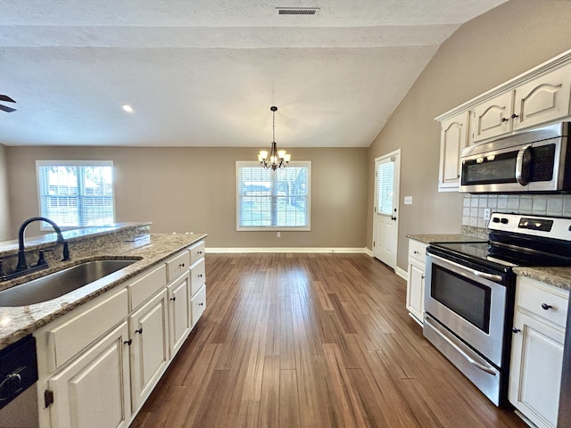 kitchen with sink, white cabinets, dark hardwood / wood-style flooring, decorative backsplash, and stainless steel appliances