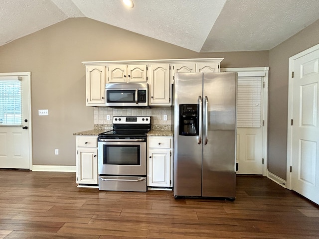 kitchen featuring white cabinetry, dark hardwood / wood-style floors, stainless steel appliances, and dark stone counters