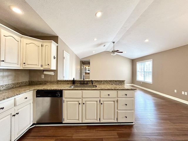 kitchen featuring vaulted ceiling, dishwasher, sink, dark hardwood / wood-style flooring, and kitchen peninsula