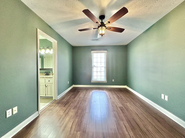 empty room featuring ceiling fan, sink, hardwood / wood-style floors, and a textured ceiling