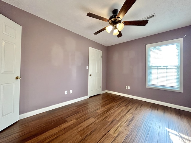 unfurnished room with dark wood-type flooring, a textured ceiling, and ceiling fan