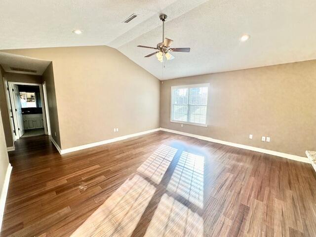 unfurnished room featuring ceiling fan, vaulted ceiling, and wood-type flooring