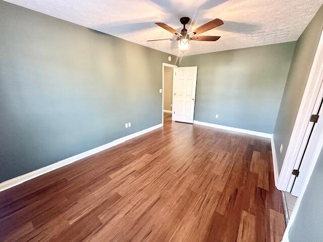 unfurnished bedroom with hardwood / wood-style flooring, a textured ceiling, and ceiling fan