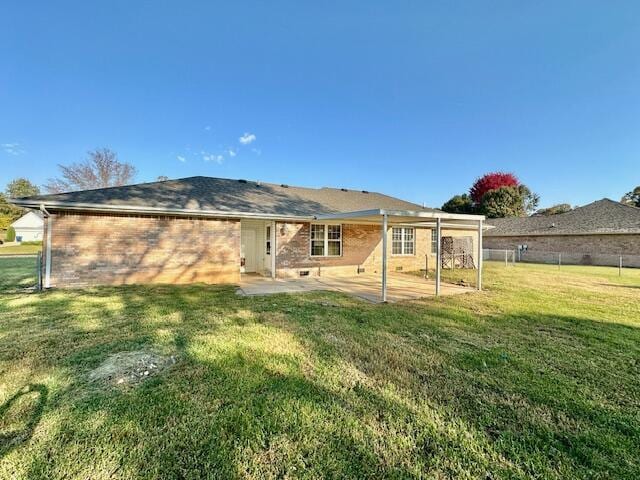 rear view of property with a yard and a patio