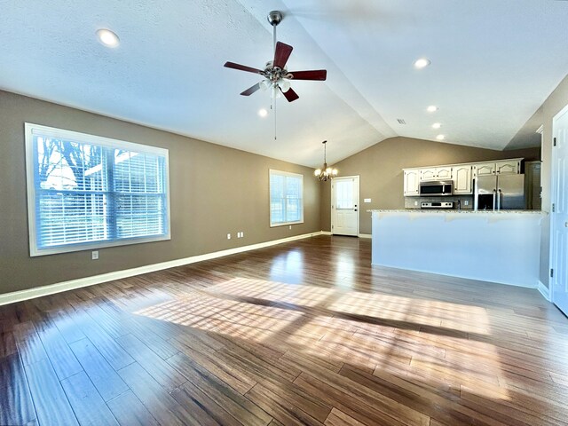 spare room featuring ceiling fan, wood-type flooring, and vaulted ceiling