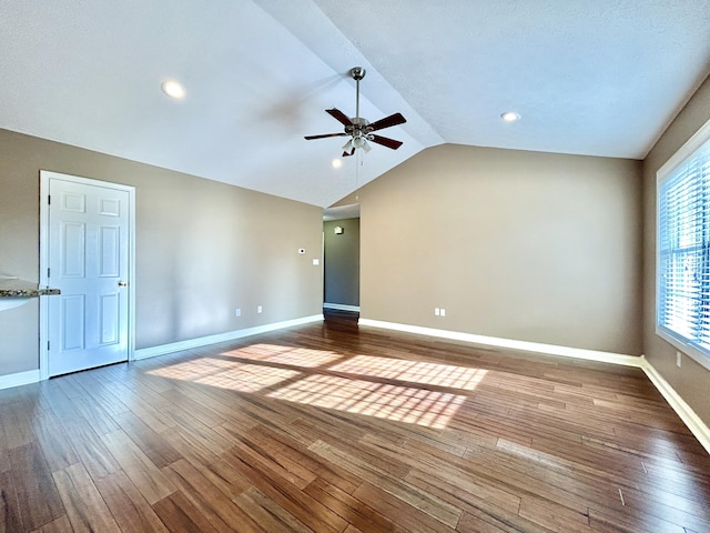 spare room featuring ceiling fan, wood-type flooring, and vaulted ceiling