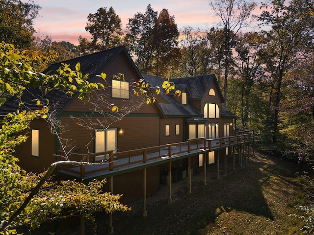 back of house at dusk with a deck